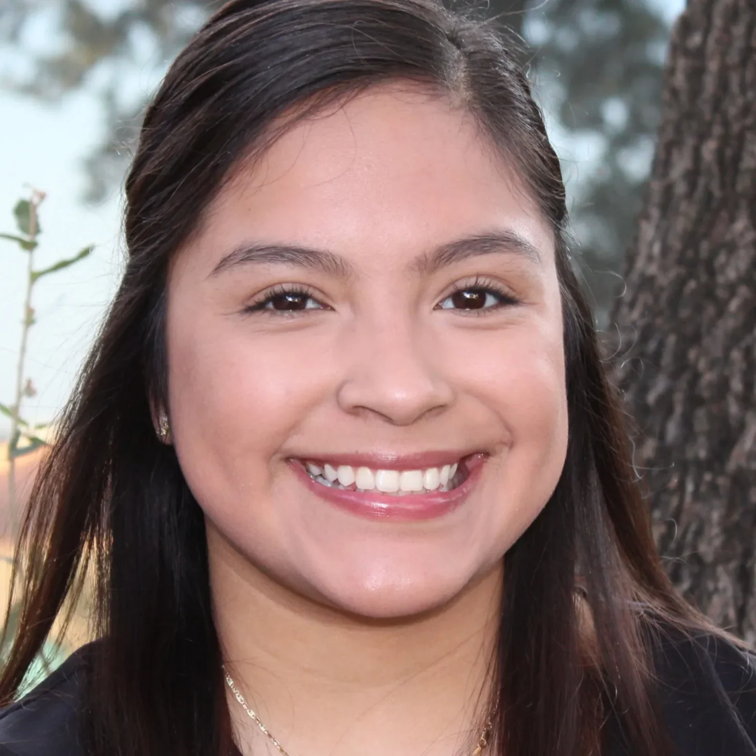 A young woman smiles for the camera.