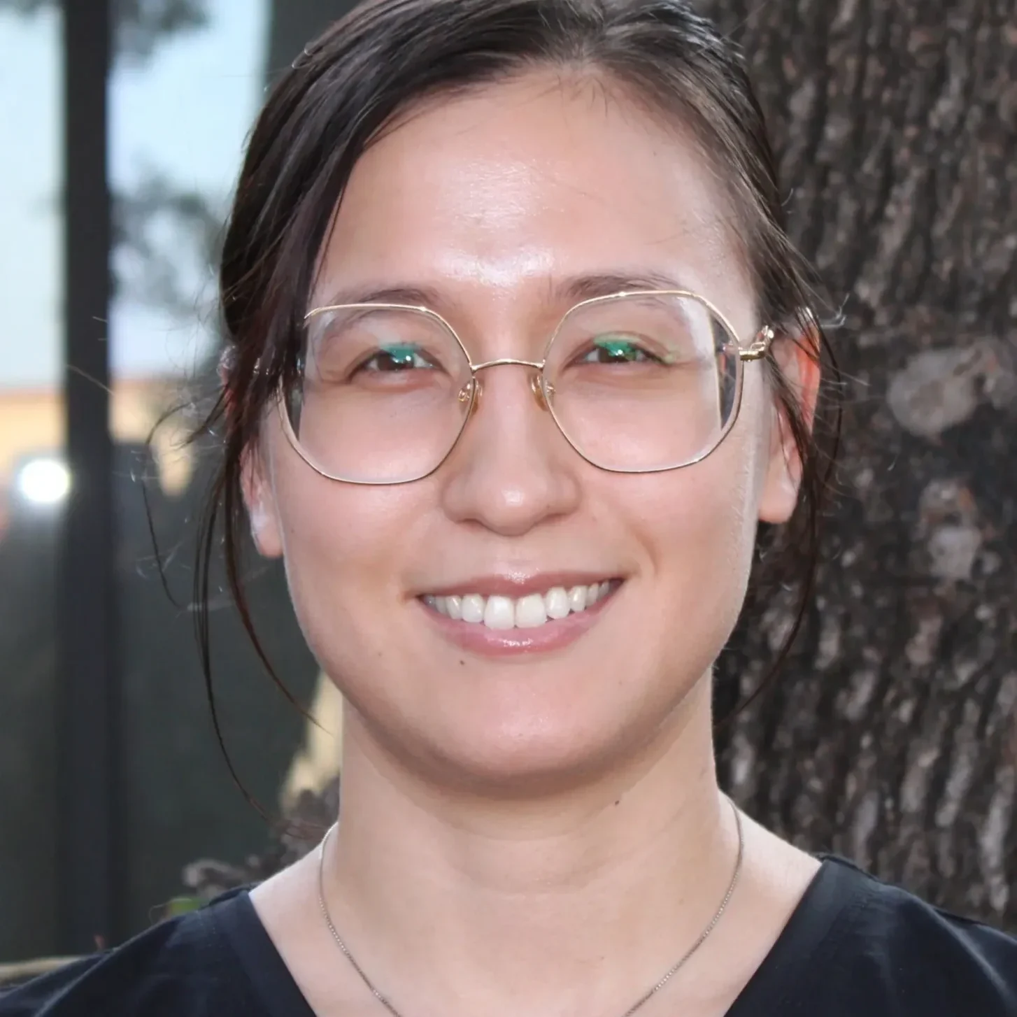 A woman with glasses smiling for the camera.