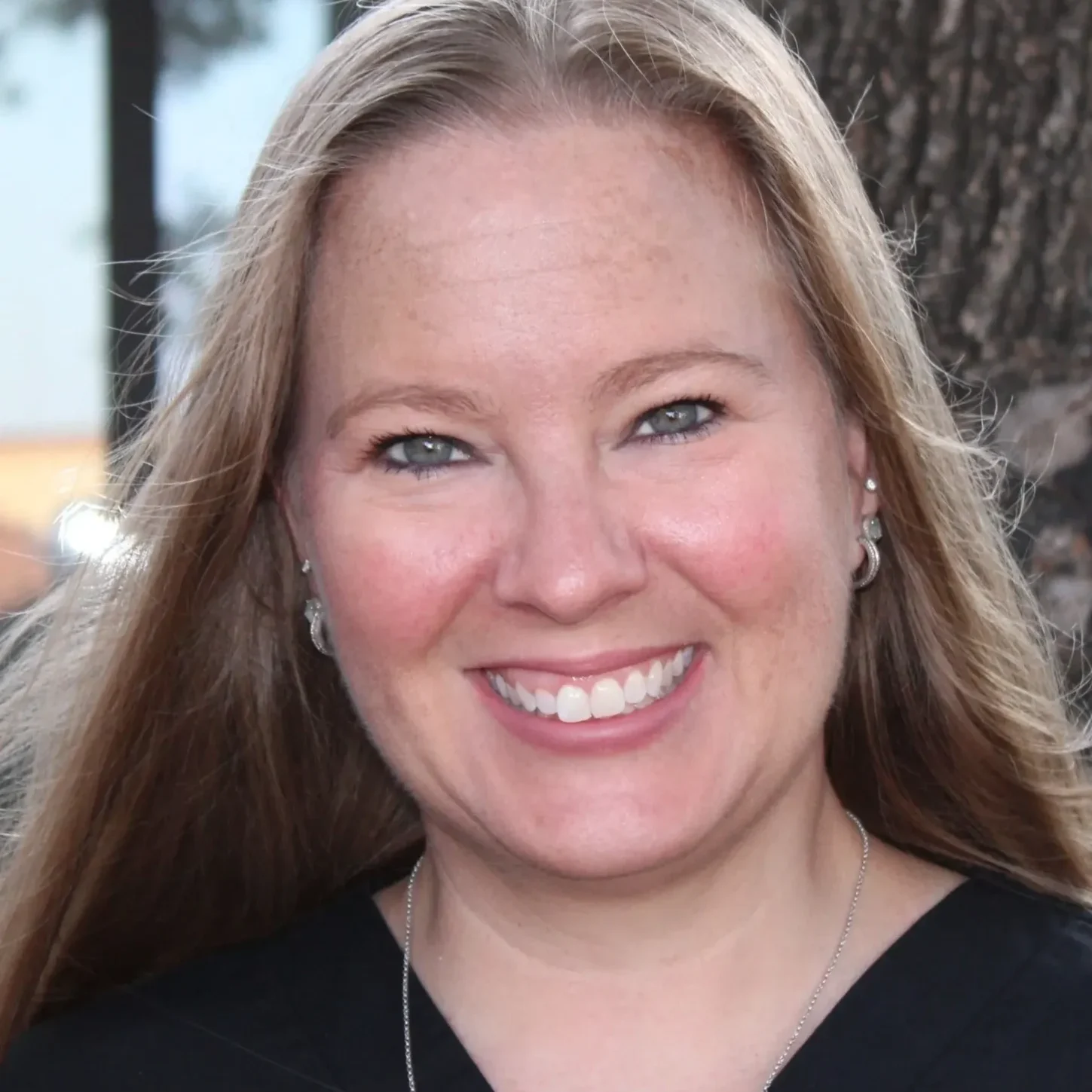 A woman with long hair smiles for the camera.